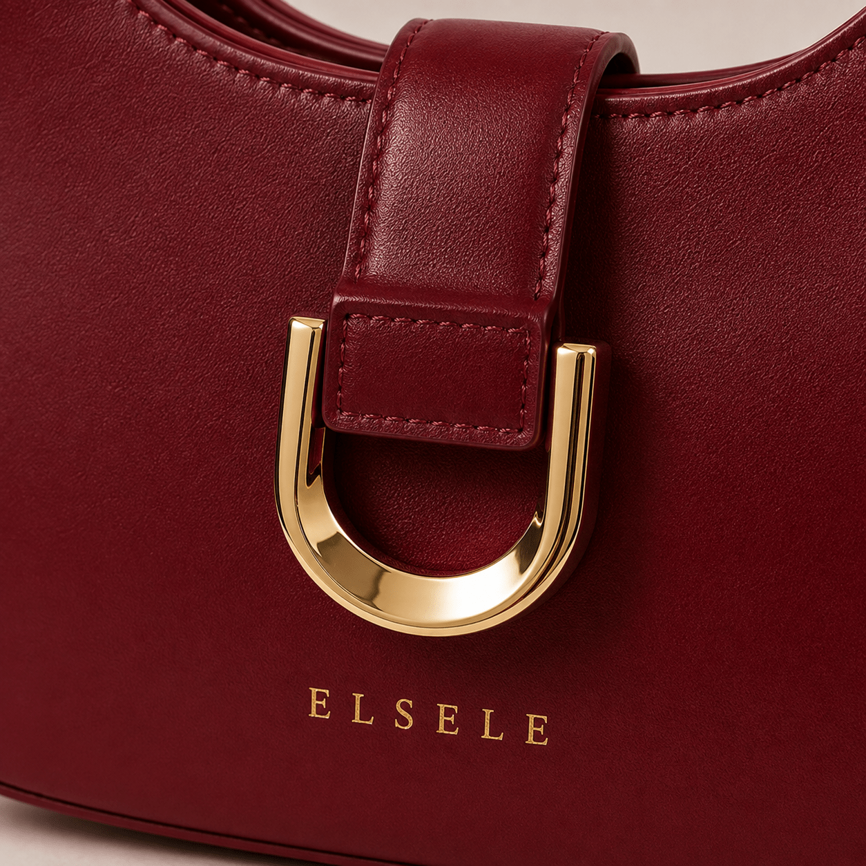 ELSELE Logo und goldener Frontverschluss Kleines goldenes ELSELE Logo und dekorativer Frontverschluss der bordeauxroten Tasche