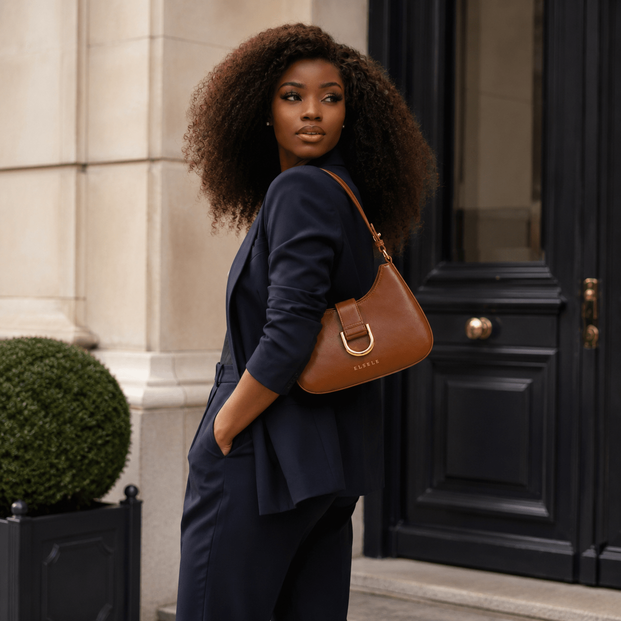 Woman carrying the Lunara Brown Leather Shoulder Bag outdoors